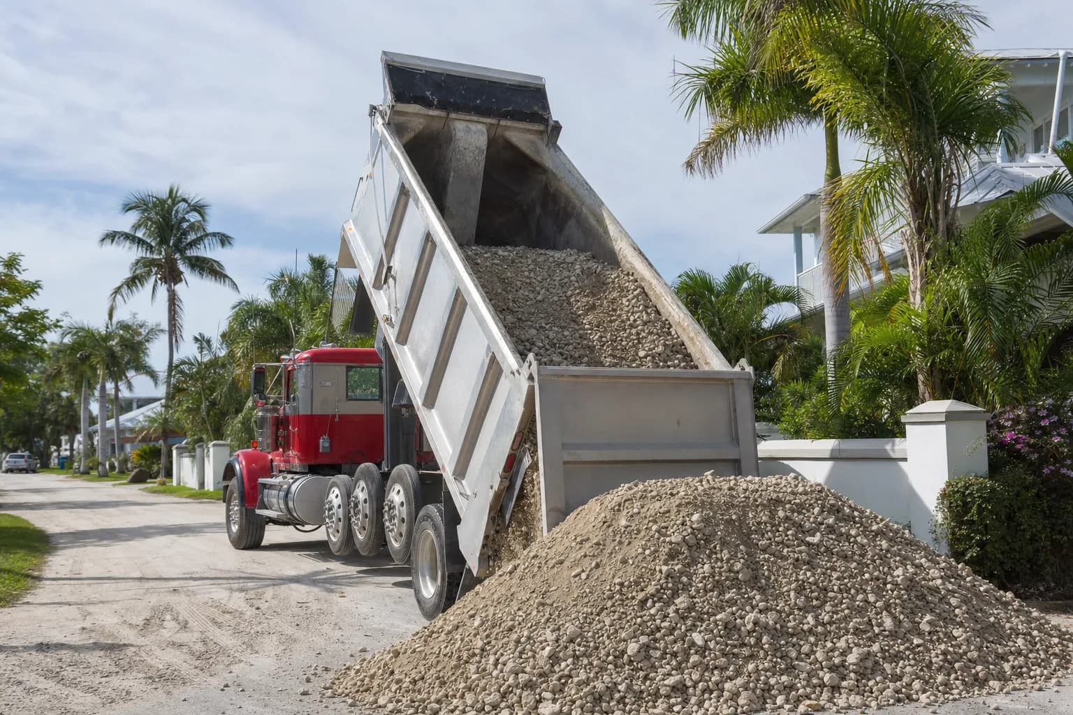 Dump truck delivering gravel to a residential property